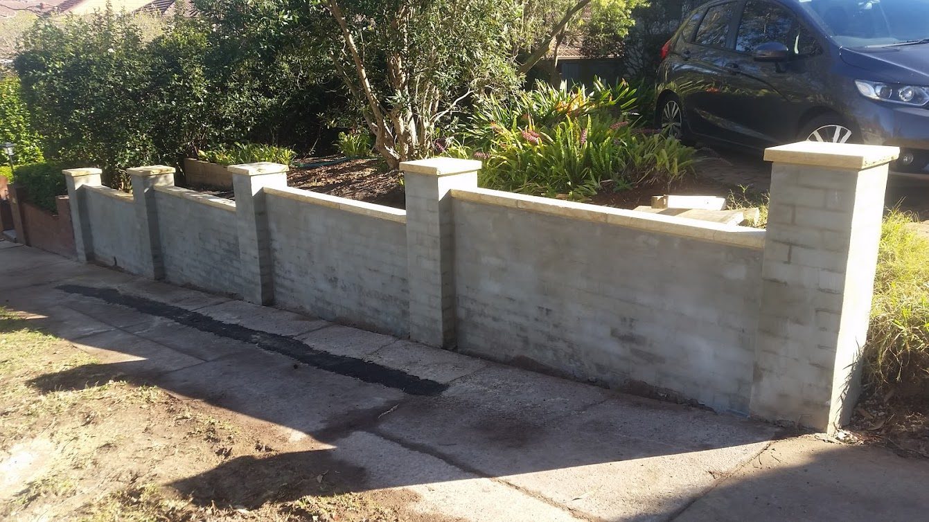 Brick fence with sandstone caps in Artarmon